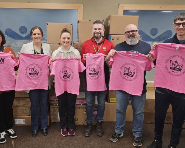Volunteers posing with shirts donated by Clow Canada for Pink Shirt Day